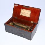 Swiss wooden music box with a brass cylinder and comb mechanism, housed under glass. The lid feature