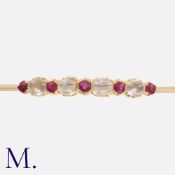 A Moonstone and Ruby Brooch in yellow gold, set with an alternating row of round cut rubies and