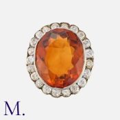 A Citrine and Diamond Cluster Ring in yellow gold and silver, set with an oval cut citrine within