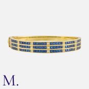 A Sapphire and Diamond Bangle in 18 carat yellow gold, set with approximately 9.00 carats of