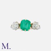 An Emerald and Diamond Ring in platinum and yellow gold, set with a cushion cut emerald weighing