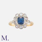 A Sapphire and Diamond Cluster Ring in yellow gold, set with an oval cut blue sapphire to the centre