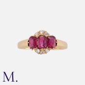 An Edwardian Ruby and Diamond Ring in yellow gold, set with three oval cut rubies, accented by