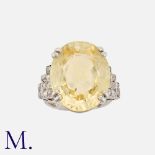 An Impressive Ceylon Yellow Sapphire and Diamond Ring in platinum, set with a large oval-cut