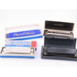 Four boxed vintage harmonicas including examples by Hohner and Bluesband.