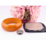 A collection comprising a sterling silver compact, a sterling silver ring and a butterscotch