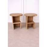 A pair of contemporary nightstands or accent tables, each featuring a solid circular oak top with an