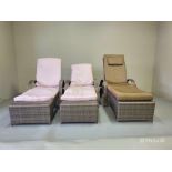 A set of three woven rattan lounge sun beds designed for outdoor or conservatory use. Each sun