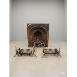 A Victorian cast iron arched fireplace insert alongside a pair of contemporary fire baskets and fire