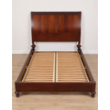 A mahogany double bedstead in the sleigh style. Comprising a high, gently curved panelled headboard,