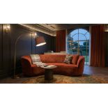 A contemporary terracotta rust crescent-shaped curved sofa, expertly upholstered in premium velvet