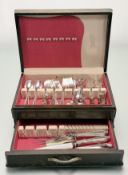 An Edwardian walnut canteen containing a part suite of Community epns and ten side knives and a