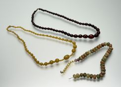A vintage dark brown amber graduated stand of fifty-four oval beads with a metal screw fastening: l.