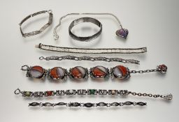 A collection of silver and white metal jewellery to include a white metal stiff hinged engraved