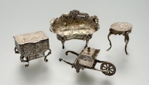 A collection of silver miniature furnituer to include a Victorain London silver sofa with all over