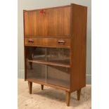 A mid-century teak bureau, fall-front revealing fitted interior over twin glazed sliding panel