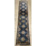 A hand-knotted Afghan Kazak runner, central geometric medallions on an indigo blue ground and