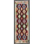 A hand-knotted Chobi kilim runner, central panel with repeating diamond and geometric motifs,
