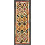 A hand-knotted Chobi kilim runner, central panel with repeating diamond and geometric motifs, yellow