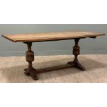 A 1920s oak refectory-style dining table, rectangular solid oak top raised on carved baluster-