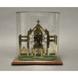 A late 20thc skeleton clock with a brass Gothic cathedral-style frame mounted on a wooden base,