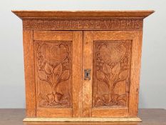 SMALL ARTS & CRAFTS OAK CABINET, frieze carved motto 'Esto Quod Esse Videris', above twin doors