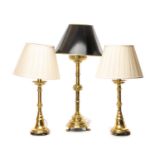 THREE GILT BRASS GOTHIC CANDLESTICK TABLE LAMPS comprising pair with knopped stems and flared
