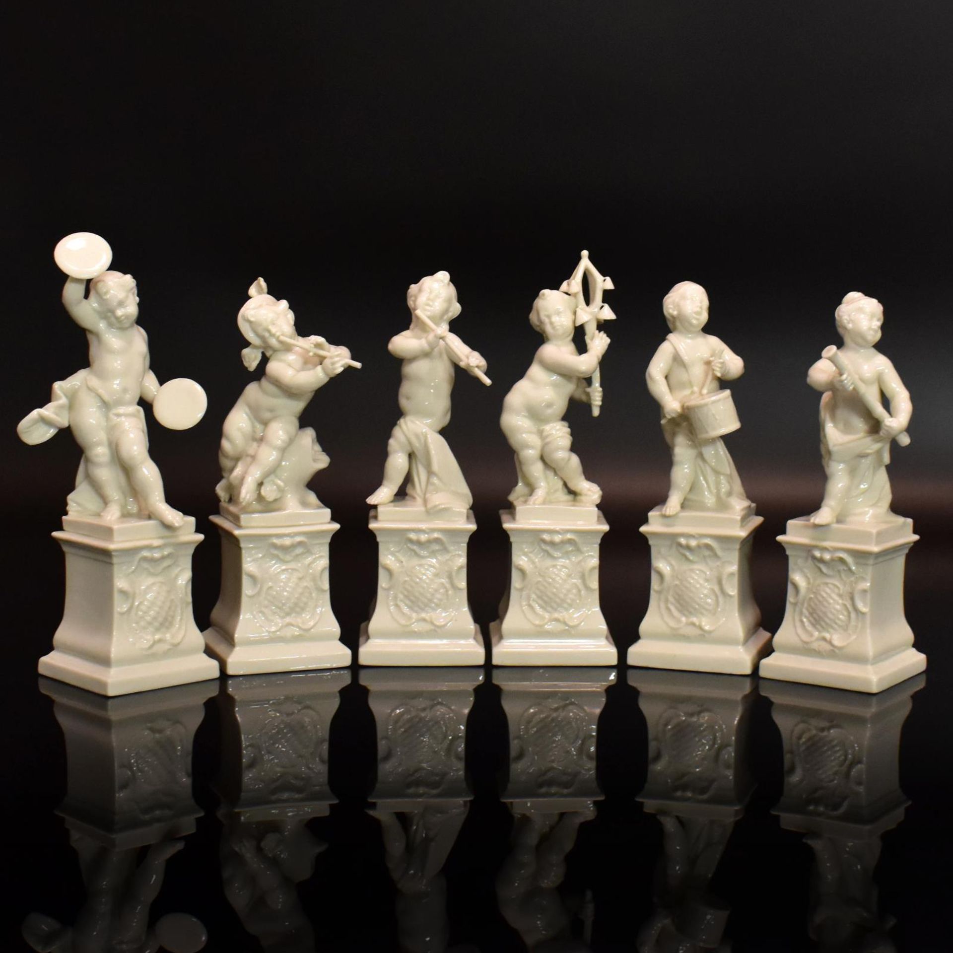 Sechs Putten auf Postamenten. Nymphenburg | Porzellan, weiß.