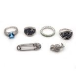 Vier Ringe und Brosche in Form einer Sicherheitsnadel. Silber.