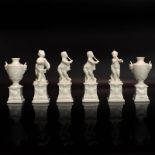 Vier Putten und zwei Ziervasen auf Postamenten. Nymphenburg | Porzellan, weiß.