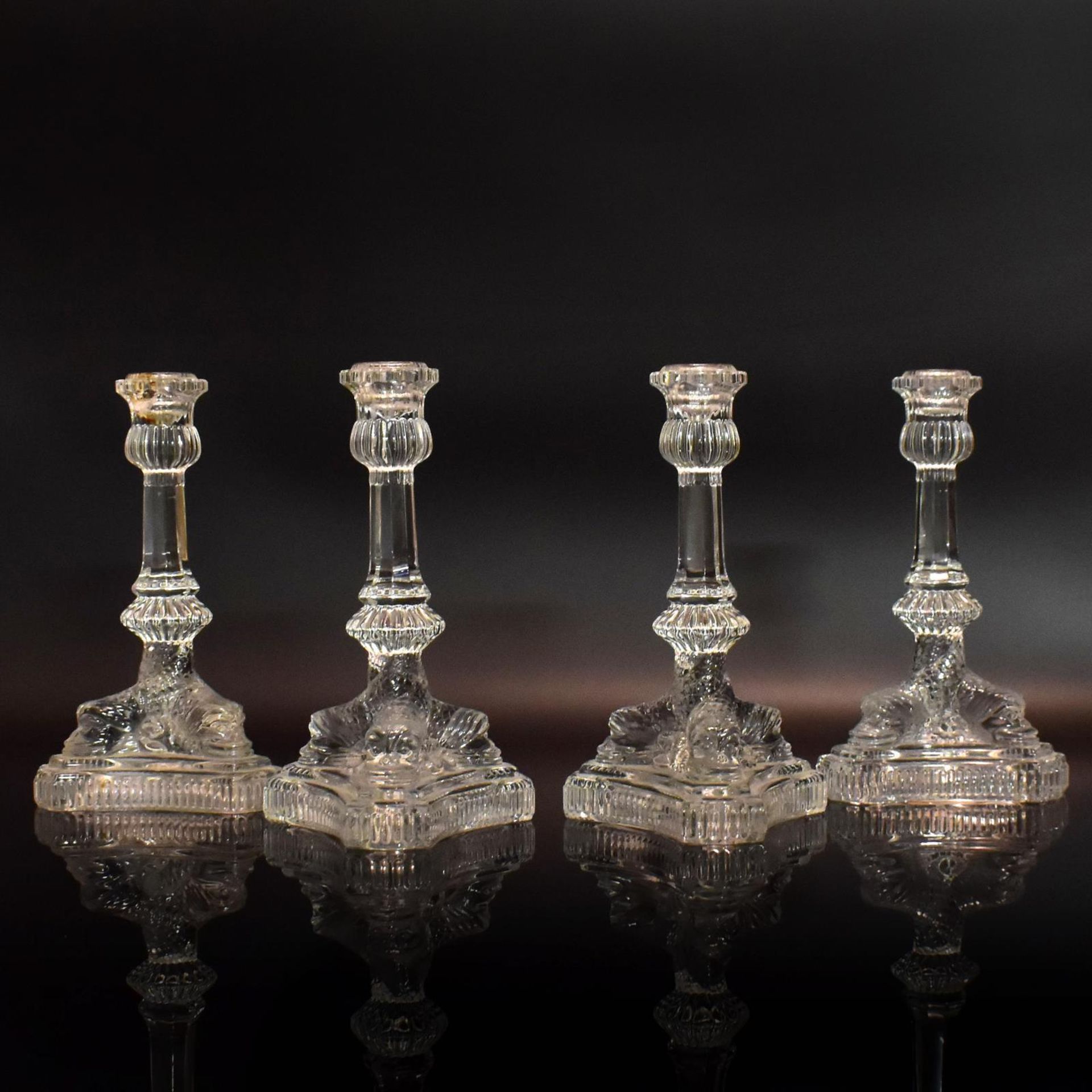 Satz von vier Kerzenleuchtern. Farbloses Pressglas.