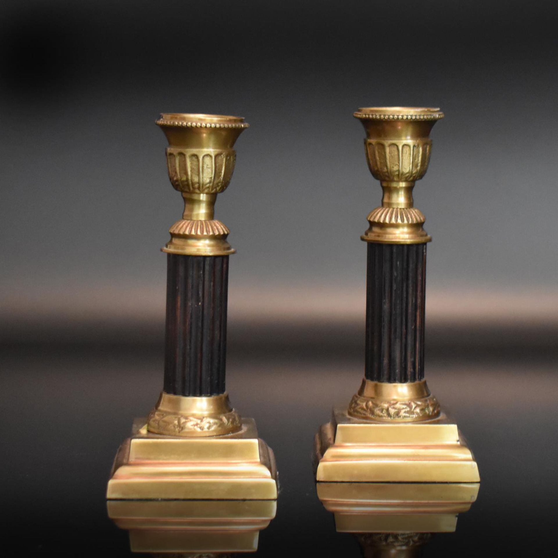 Ein Paar Kerzenleuchter. Empirestil | Bronze, teils geschwärzt.