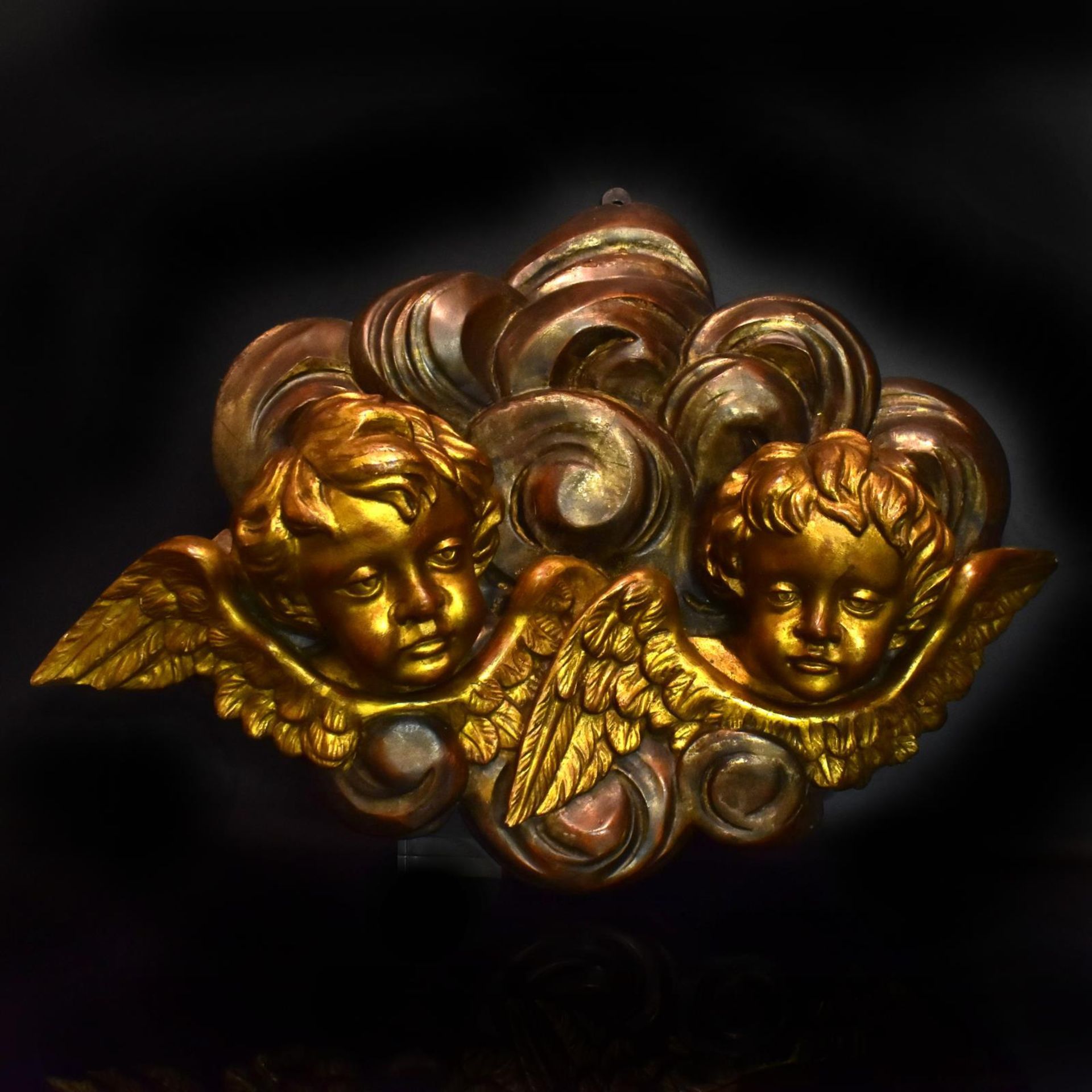 Zwei Puttenköpfe in Wolkenbank. 19./20. Jh. | Holz, geschnitzt, Farb- und Goldfassung.