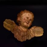 Geflügelter Puttenkopf. 19. Jh. | Holz, geschnitzt, farbig gefasst.