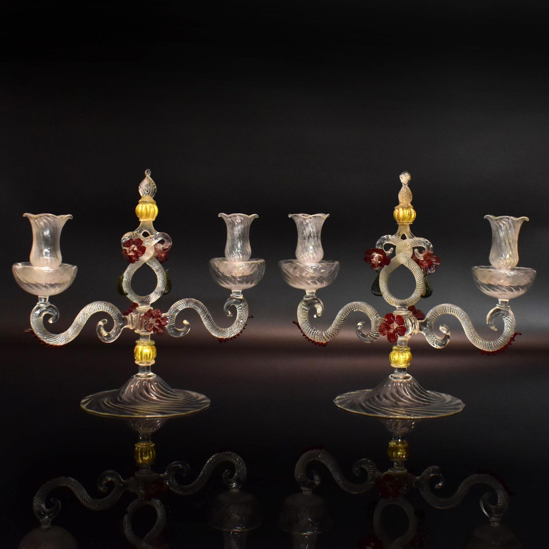 Ein Paar Kerzenleuchter. Wohl Murano, 20. Jh. | Farbloses, rotes und grünes Glas, tlw. Goldflitte...