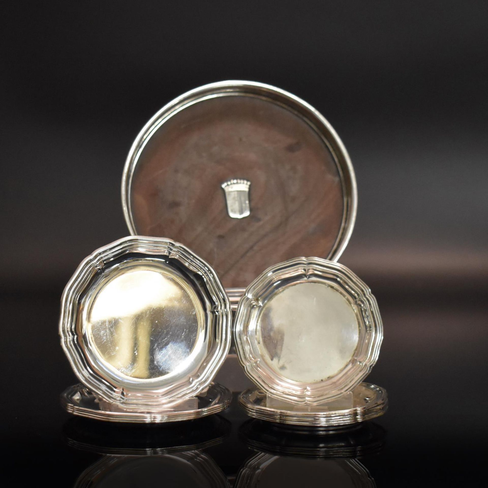 Flaschenuntersetzer und elf Gläseruntersetzer. Silber, tlw. Holzkern.