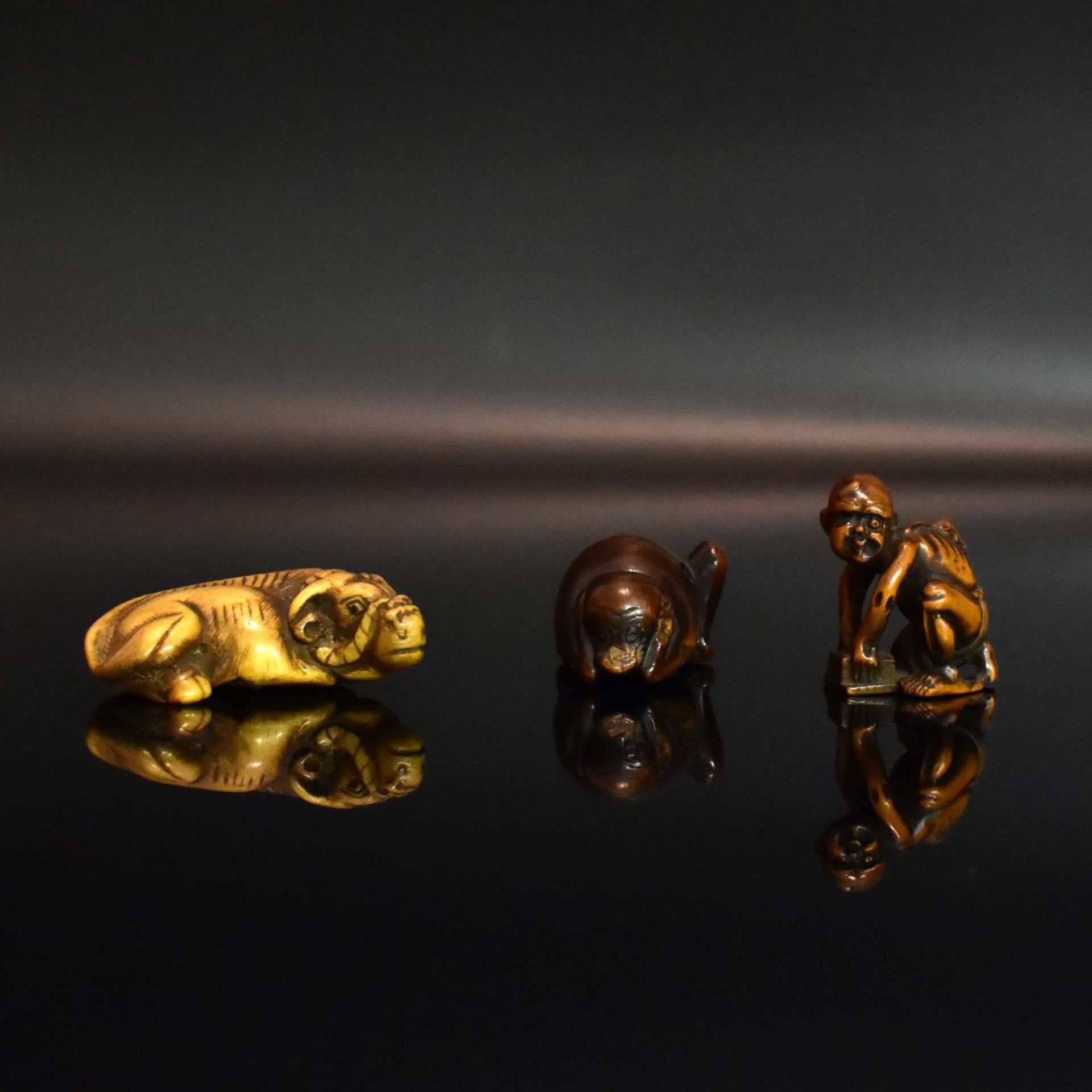 Zwei Netsuke und ein Okimono. Japan, spätes 18. Jh. / 19. Jh. | Horn bzw. Buchsbaum, geschnitzt.