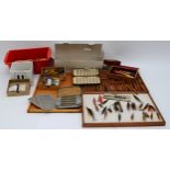 A collection of mid twentieth century and later hand tied fly fishing flies and lures displayed in