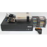 A Nintendo Entertainment System (NES) in a plastic case, with two controllers, a Game Genie and 18