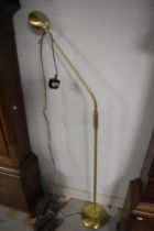 A modern brass adjustable reading lamp
