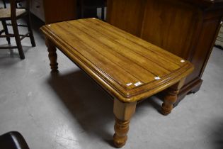 A modern coffee table, possibly yew wood, on chunky turned legs, approx. 117cm