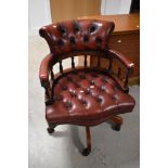 A modern red leather button back swivel chair
