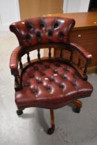 A modern red leather button back swivel chair