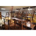 A set of five (three plus two) dark stained Ercol kitchen chairs having high spindle back chairs