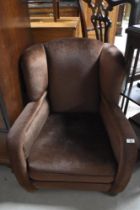 A vintage dralon low seat armchair, on bun feet