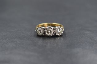 An 18ct gold diamond trilogy ring having three brilliant cut diamonds totalling approx 1ct in an
