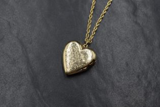 A yellow metal heart shaped locket stamped 10 KO having scroll & floral decoration on an 18ct gold