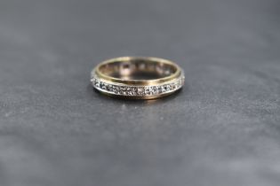 A 9ct gold clear gemstone likely topaz or sapphire set full eternity band, the round cut gemstones