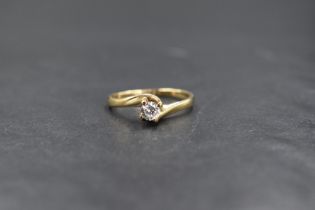 A 9ct gold cubic zirconia set solitaire ring, the round brilliant cut cubic zirconia in a cross over