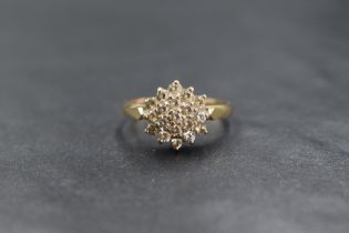 A 9ct gold cubic zirconia set cluster ring, the nineteen round cut cubic zirconia in a step setting,